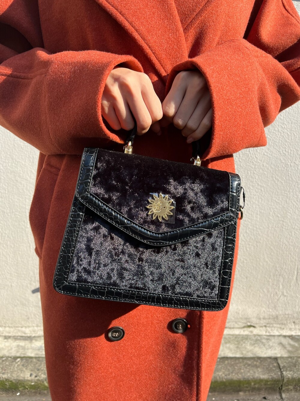 ブラック系のワンピース、オレンジ系のその他アウター、ブラック系のショルダーバッグを着用したレディースの冬コーディネートの7枚目の写真