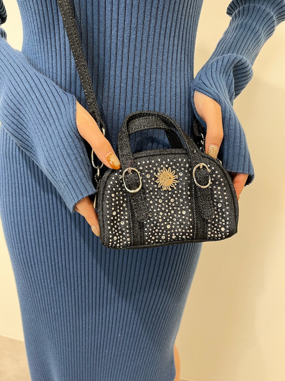 ブラック系のムートンコート、ブルー系のワンピース、ブラック系のブーツを着用したレディースの冬コーディネートの7枚目の写真