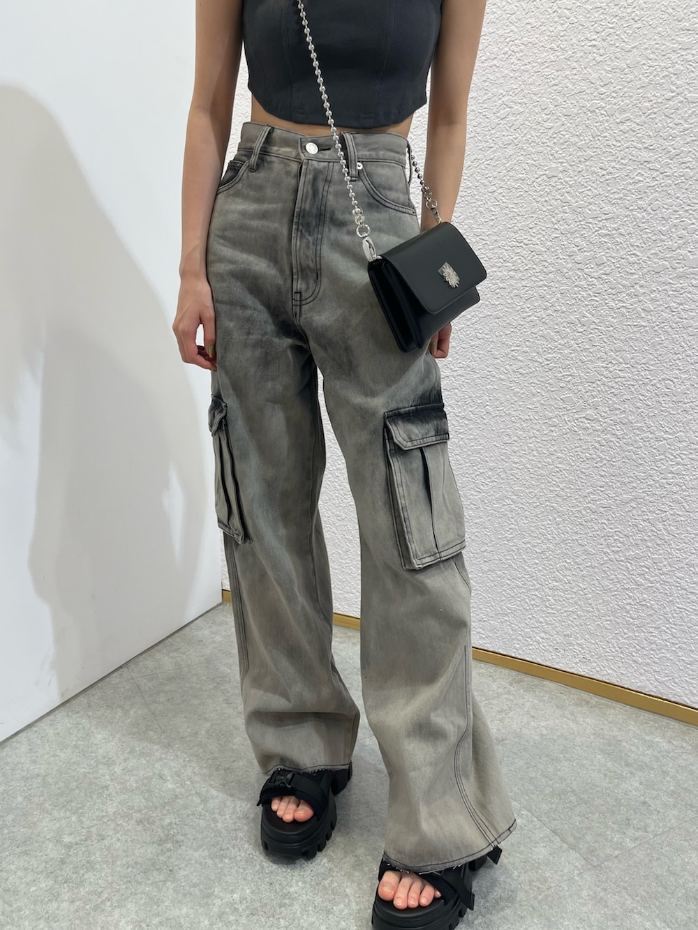 シルバー系のショルダーバッグ、ブラック系のキャミソール、ブラック系のデニムパンツを着用したレディースの夏コーディネートの5枚目の写真