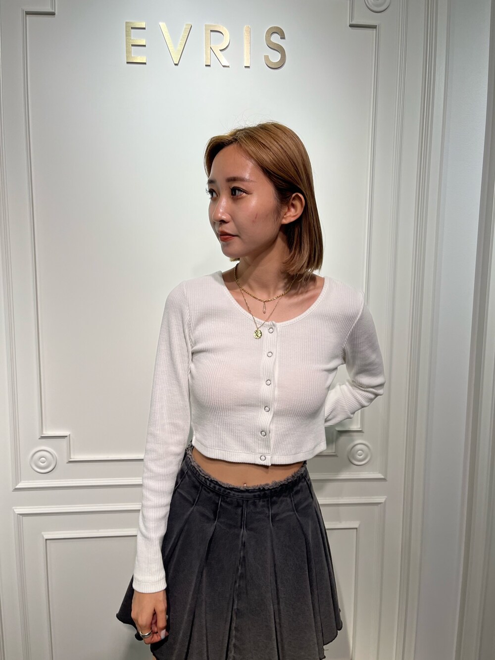 ホワイト系のTシャツ/カットソー、ブラック系のデニムスカート、ブラック系のブーツを着用したレディースの夏コーディネートの4枚目の写真
