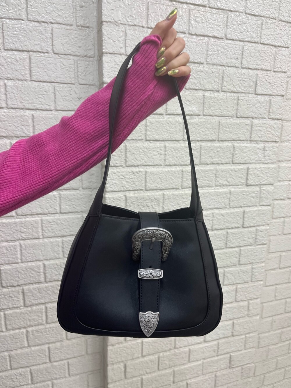 ブルー系のデニムパンツ、ホワイト系のブーツ、ブラック系のハンドバッグを着用したレディースの冬コーディネートの4枚目の写真