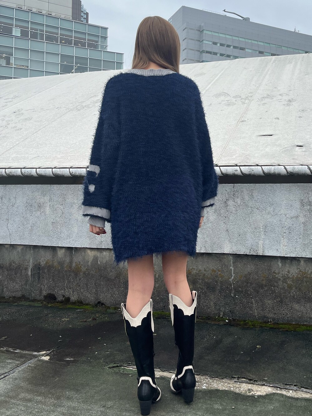 ホワイト系のスカート、ブラウン系のブーツ、ブルー系のニット/セーターを着用したレディースの秋コーディネートの6枚目の写真