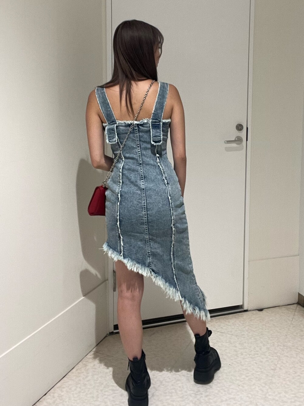 シルバー系のブーツ、ブルー系のワンピース、レッド系のショルダーバッグを着用したレディースの夏コーディネートの2枚目の写真