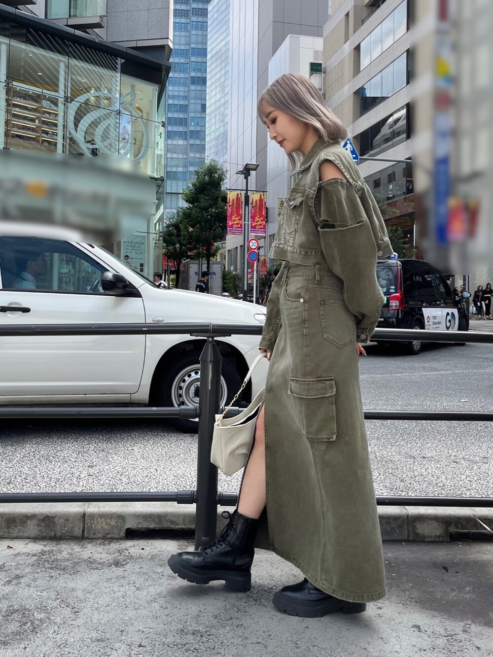 グリーン系のデニムジャケット、グリーン系のデニムスカート、ブラック系のハンドバッグを着用したレディースの秋コーディネートの3枚目の写真