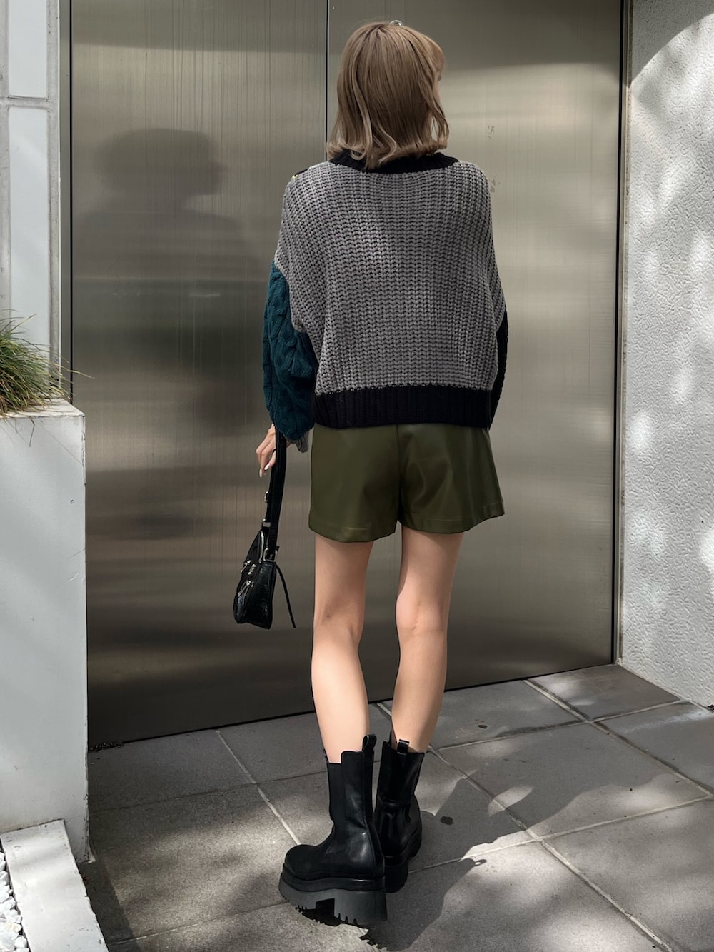 ホワイト系のブーツ、ブラック系のショルダーバッグ、ブラック系のニット/セーターを着用したレディースの秋コーディネートの5枚目の写真