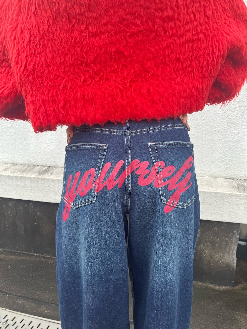 ブラック系のブーツ、レッド系のニット/セーター、ブルー系のデニムパンツを着用したレディースの冬コーディネートの6枚目の写真