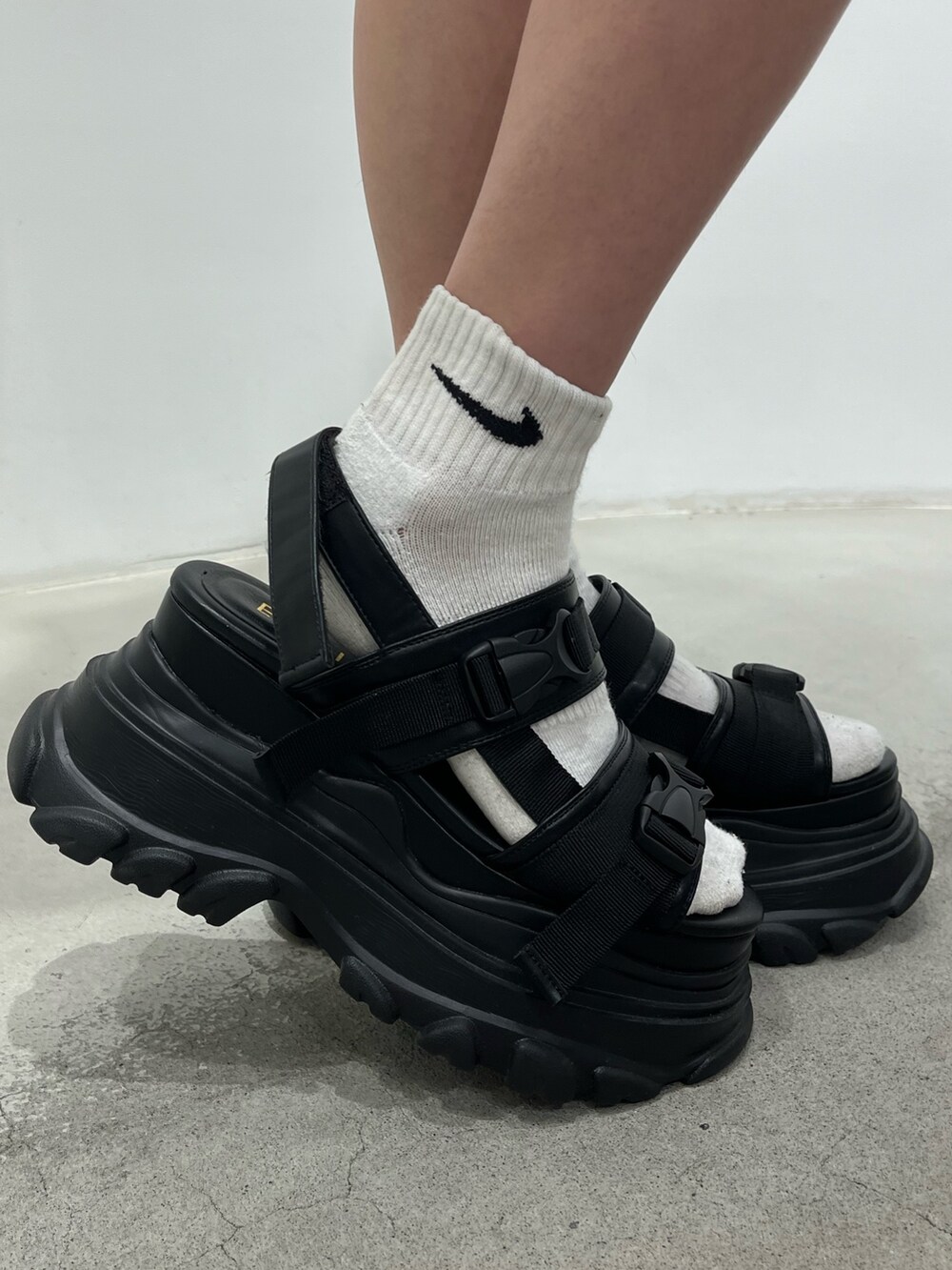 グリーン系のワンピース、ブラック系のサンダル、ブラック系のショルダーバッグを着用したレディースの春コーディネートの7枚目の写真