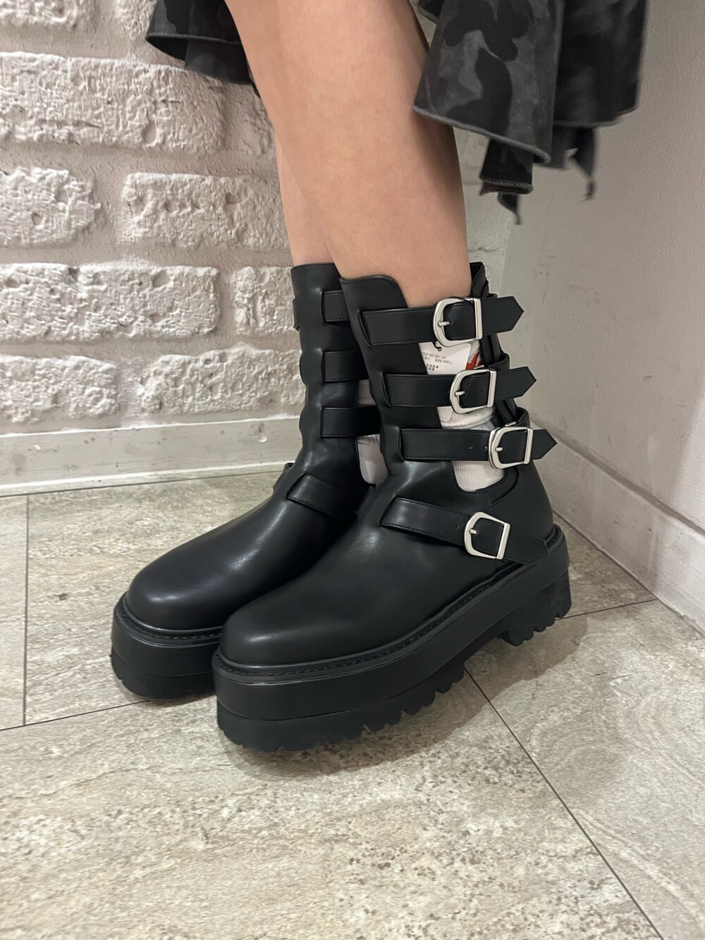 ブラック系のスウェット、ブラック系のスカート、ブラック系のブーツを着用したレディースの春コーディネートの5枚目の写真