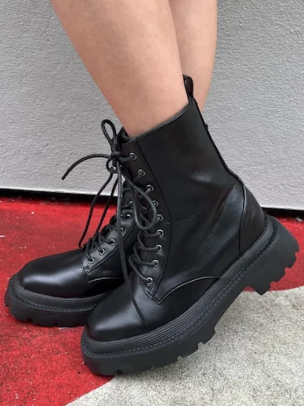 ブラック系のブーツ、ブラック系のデニムパンツ、ブラック系のハンドバッグを着用したレディースの春コーディネートの7枚目の写真