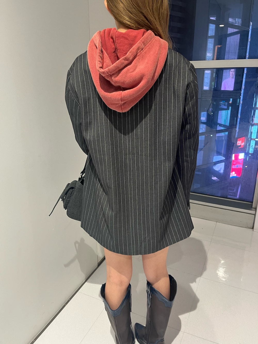 グレー系のテーラードジャケット、グレー系のスカート、レッド系のスウェットを着用したレディースの秋コーディネートの5枚目の写真