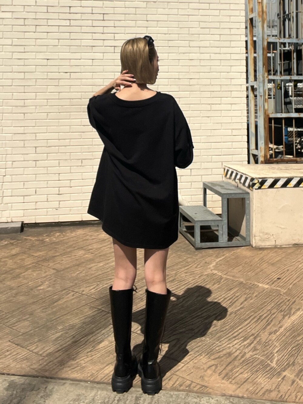 ブラック系のTシャツ/カットソー、ブラック系のブーツ、ブラック系のサングラスを着用したレディースの春コーディネートの4枚目の写真