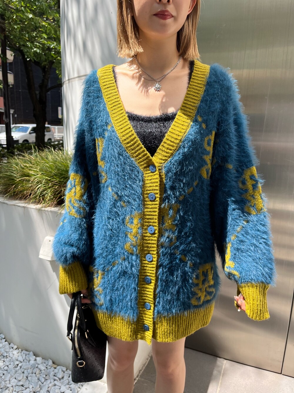 ブルー系のカーディガン/ボレロ、ブラック系のブーツ、ブラック系のショルダーバッグを着用したレディースの秋コーディネートの6枚目の写真