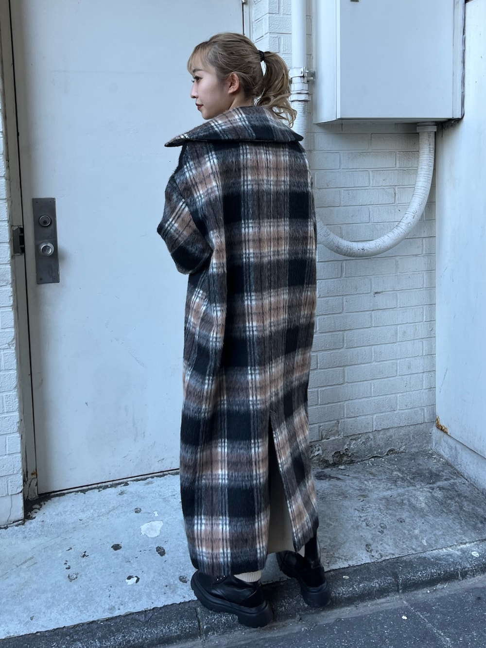 ホワイト系のワンピース、グリーン系のその他アウター、ブラック系のブーツを着用したレディースの冬コーディネートの3枚目の写真