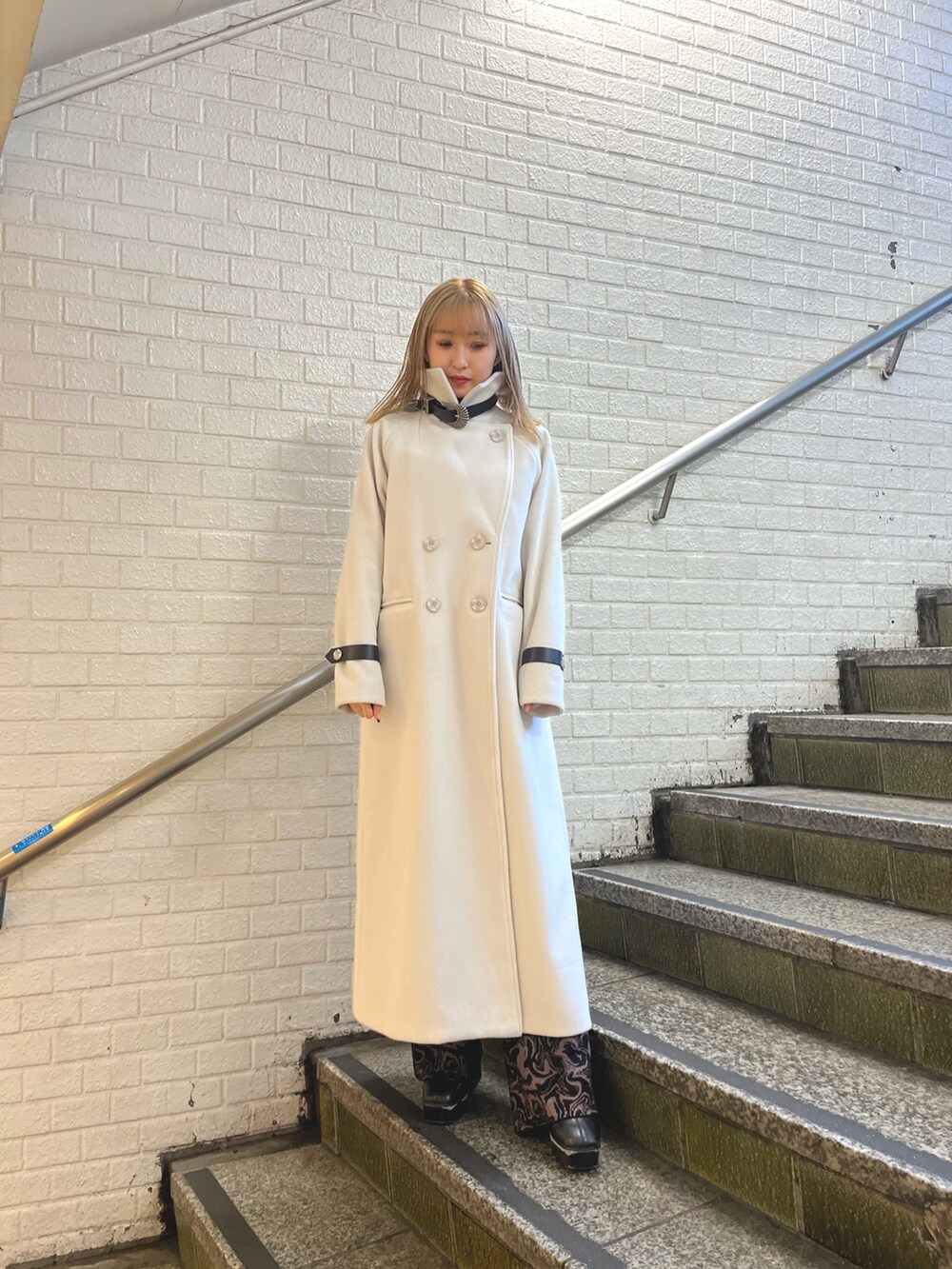 ホワイト系のその他アウター、ブラック系のその他パンツ、ブラック系のショルダーバッグを着用したレディースの冬コーディネートの3枚目の写真