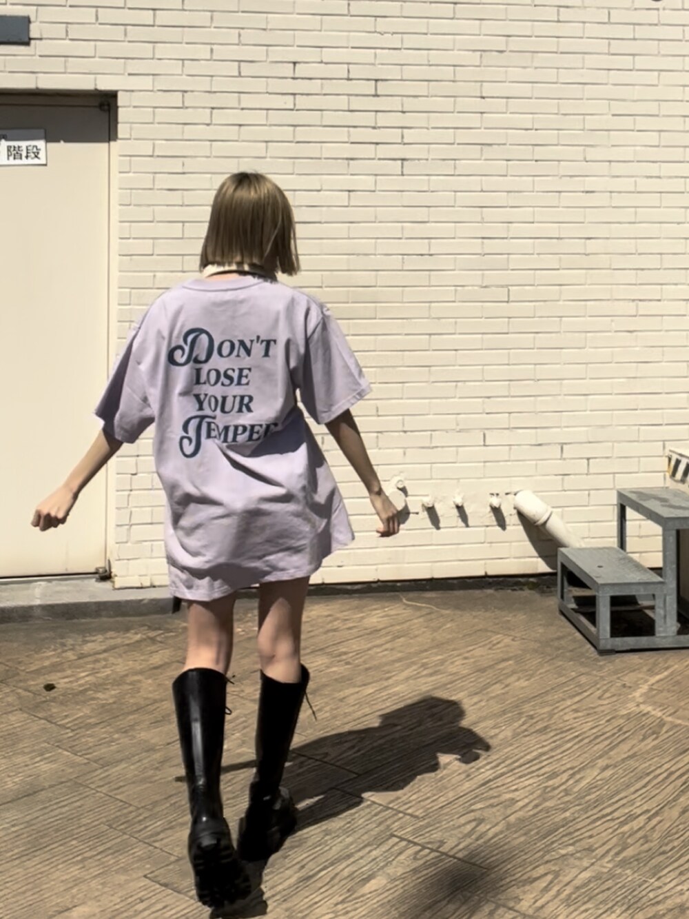 パープル系のTシャツ/カットソー、ブラック系のブーツを着用したレディースの春コーディネートの2枚目の写真