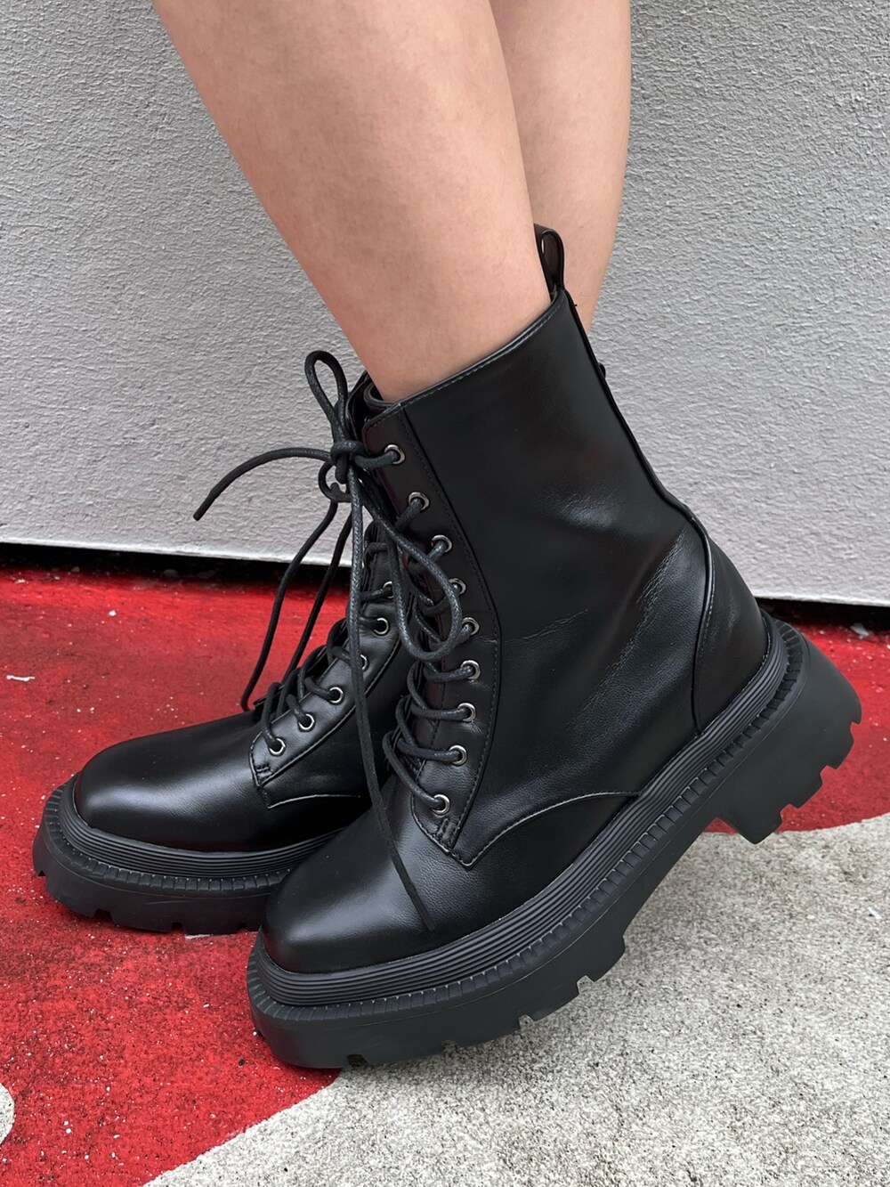 ブラック系のワンピース、ブラック系のブーツを着用したレディースの春コーディネートの6枚目の写真