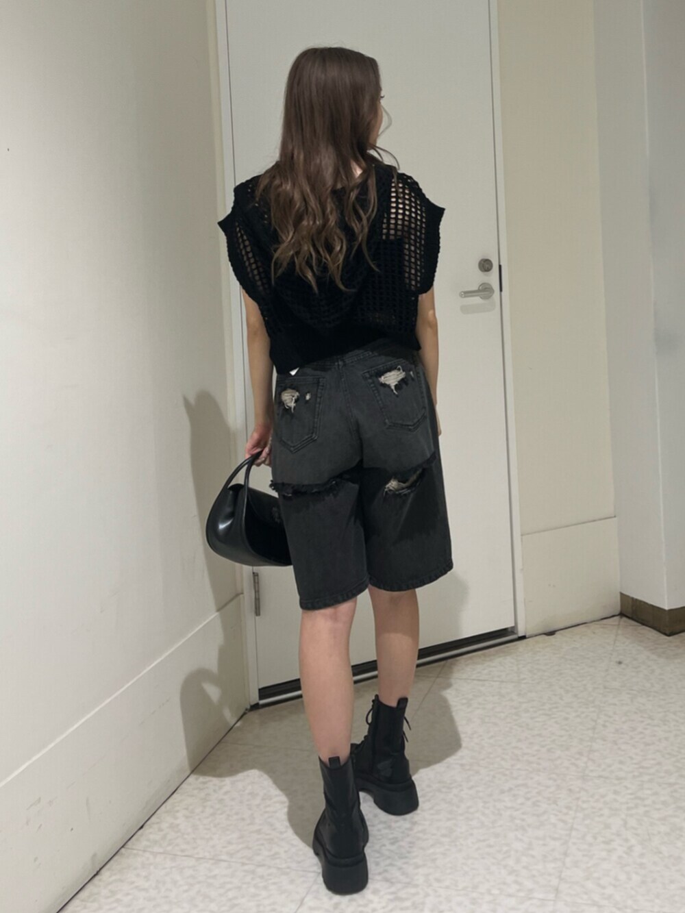 ブラック系のブーツ、ブラック系のハンドバッグ、ブラック系のキャミソールを着用したレディースの夏コーディネートの3枚目の写真