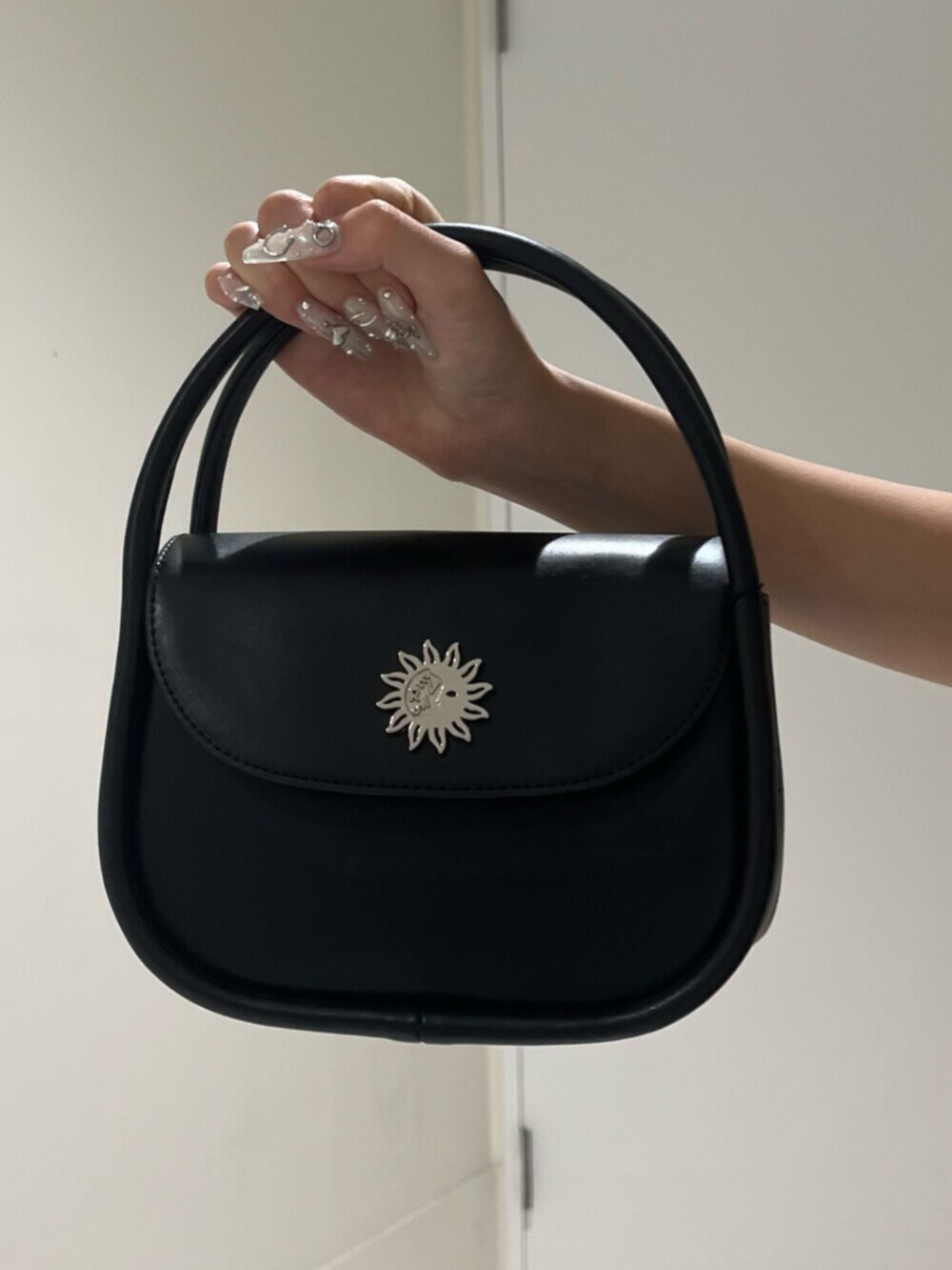 ブラック系のブーツ、ブラック系のハンドバッグ、ブラック系のデニムパンツを着用したレディースの夏コーディネートの6枚目の写真