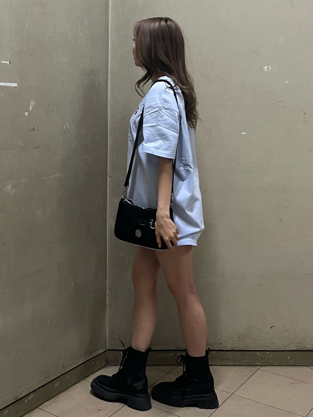 ブラック系のショルダーバッグ、ブラック系のブーツ、ブルー系のTシャツ/カットソーを着用したレディースの春コーディネートの2枚目の写真
