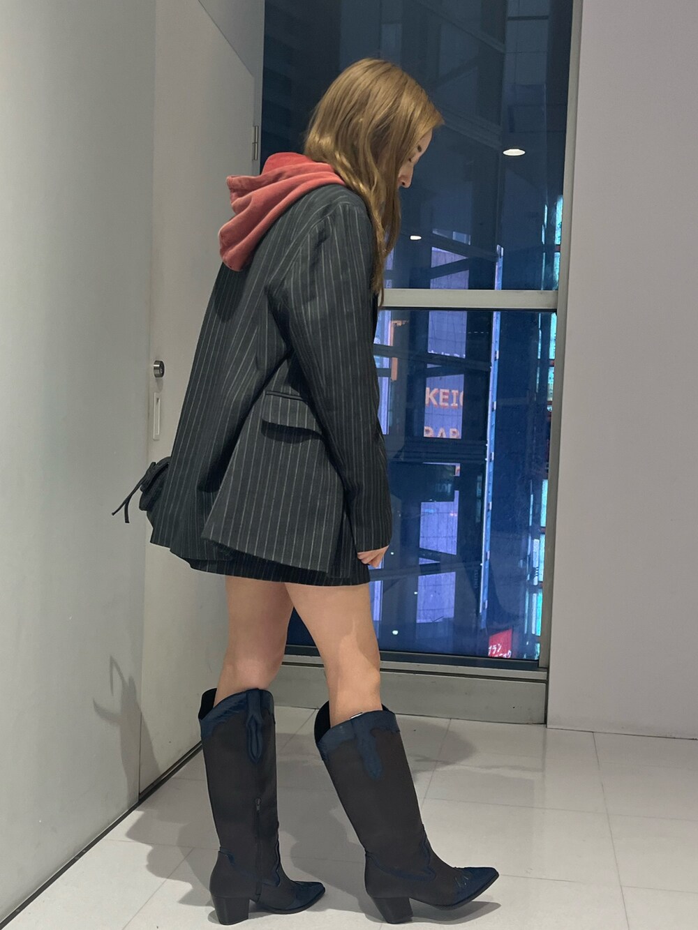 グレー系のテーラードジャケット、グレー系のスカート、レッド系のスウェットを着用したレディースの秋コーディネートの2枚目の写真