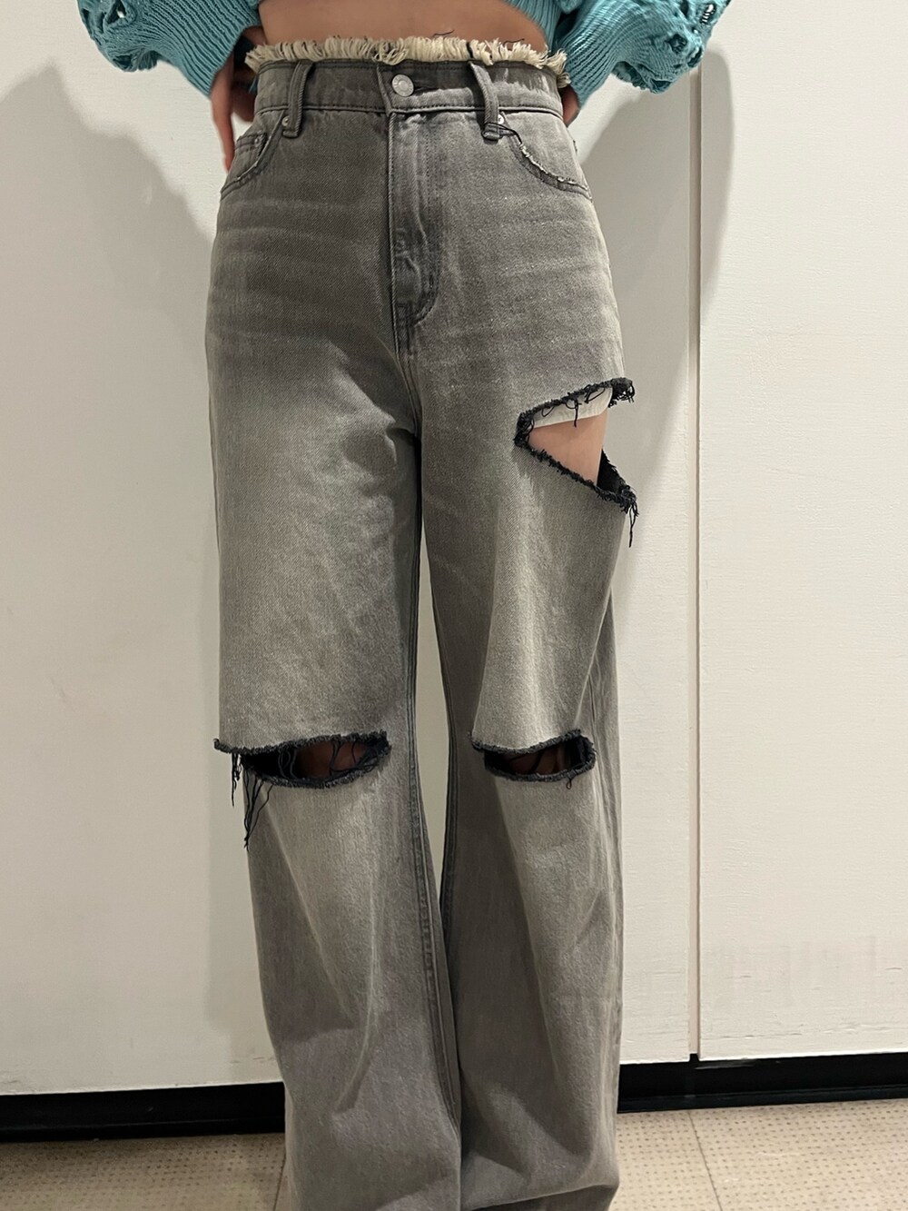 ブラック系のデニムパンツ、ピンク系のカーディガン/ボレロ、ブラック系のブーツを着用したレディースの冬コーディネートの7枚目の写真