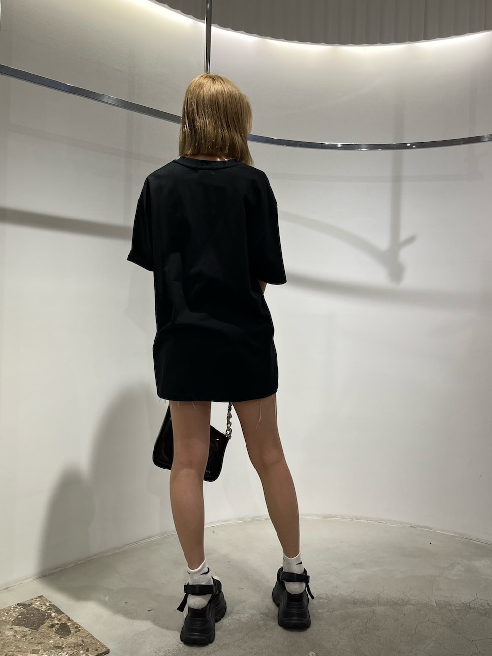 ブラック系のサンダル、ホワイト系のハンドバッグ、ホワイト系のTシャツ/カットソーを着用したレディースの夏コーディネートの2枚目の写真