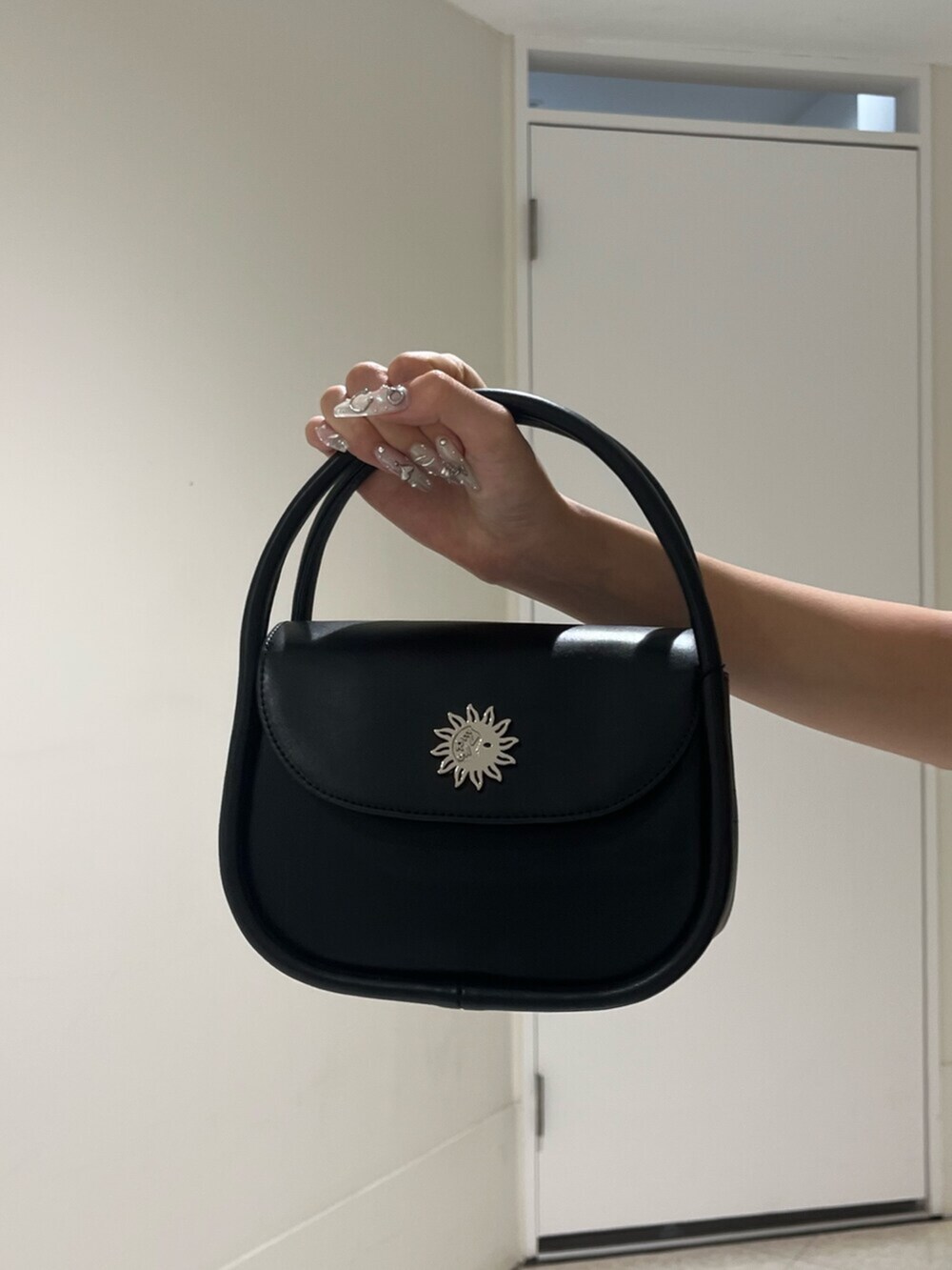 ブラック系のブーツ、ブラック系のハンドバッグ、ブラック系のワンピースを着用したレディースの夏コーディネートの6枚目の写真