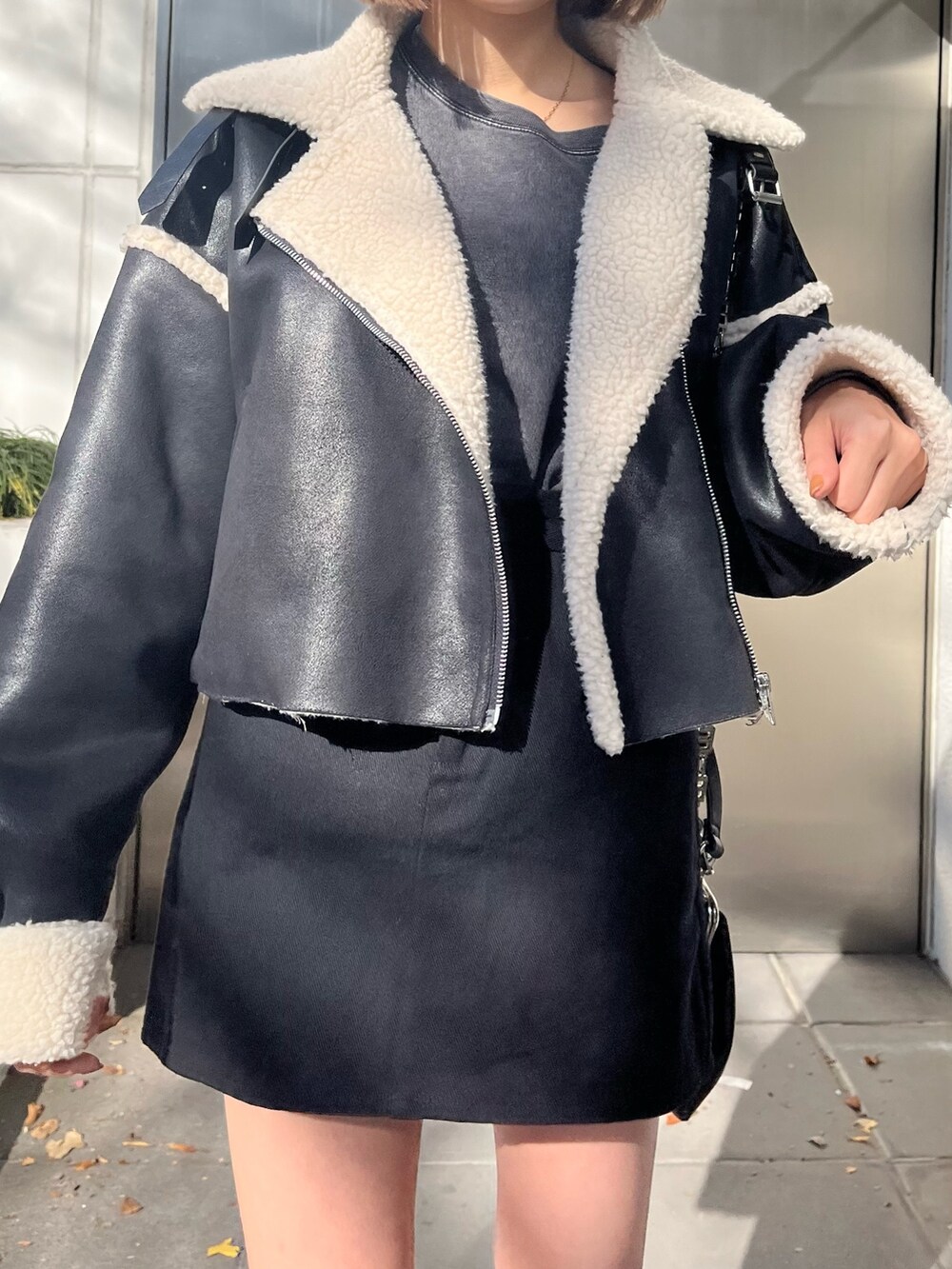 ブラック系のブルゾン、グレー系のTシャツ/カットソー、ブラック系のブーツを着用したレディースの冬コーディネートの4枚目の写真