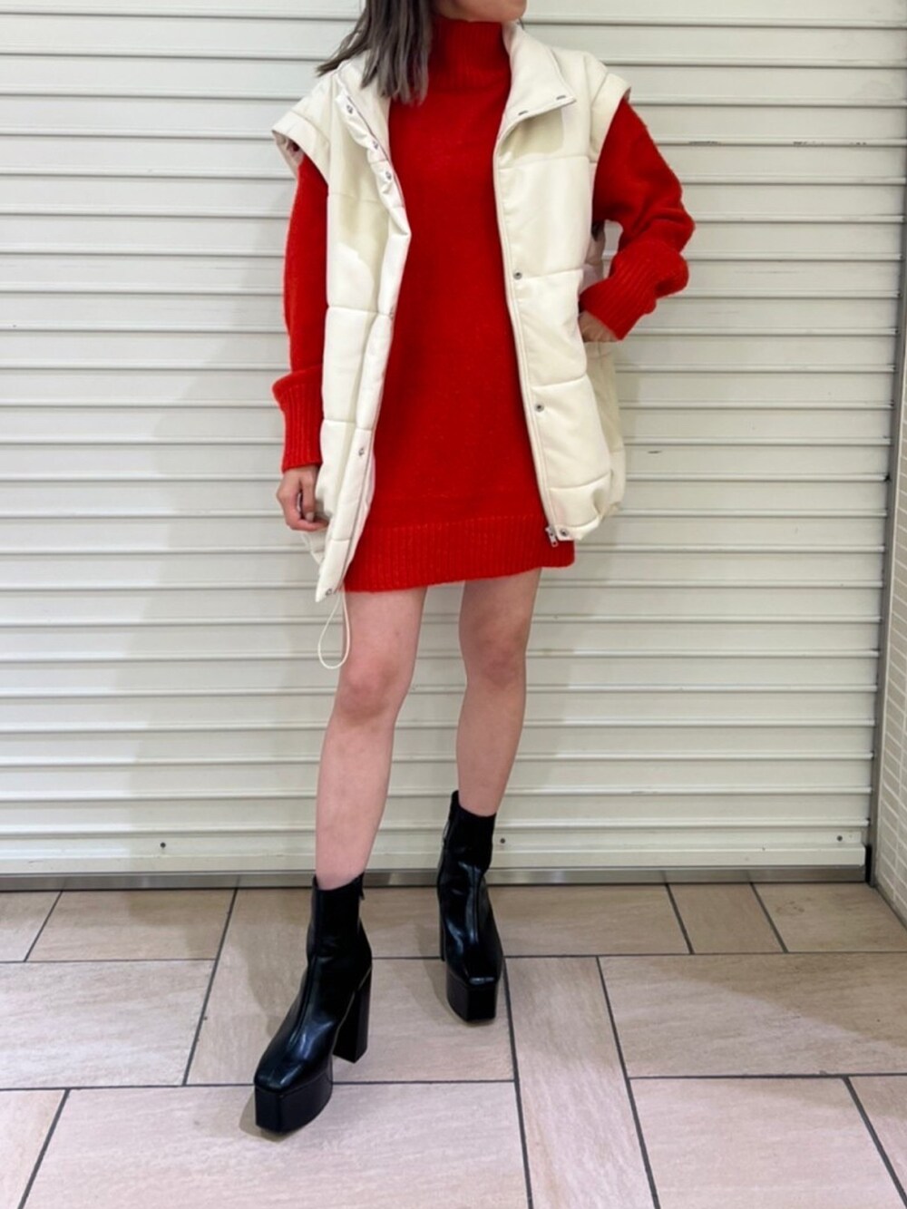 ホワイト系のブルゾン、レッド系のワンピースを着用したレディースの秋コーディネートの2枚目の写真