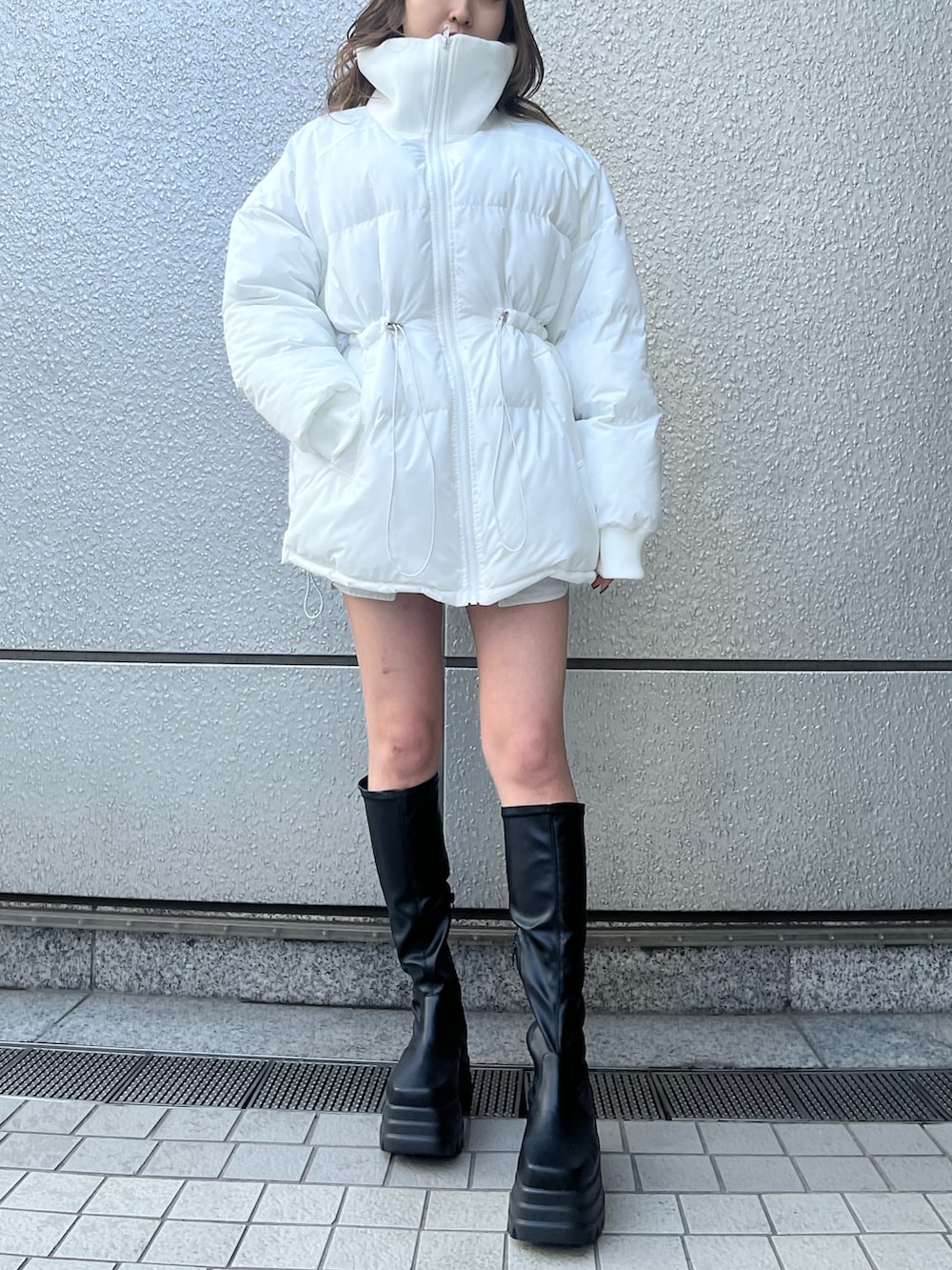 ブラック系のデニムスカート、ブラック系のTシャツ/カットソー、ブラック系のブーツを着用したレディースの冬コーディネートの5枚目の写真