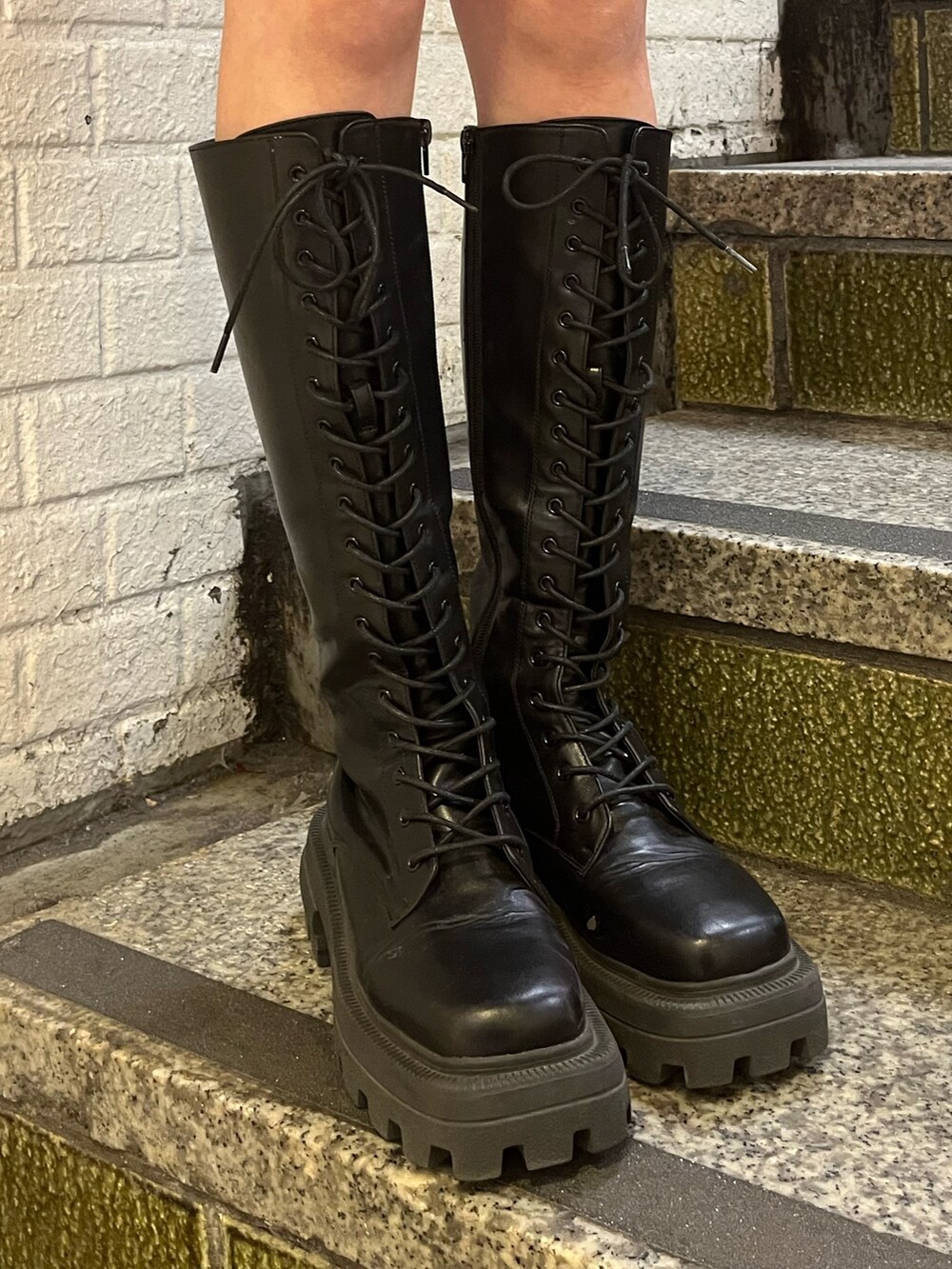 ブラック系のワンピース、ブラック系のハンドバッグ、ブラック系のブーツを着用したレディースの冬コーディネートの6枚目の写真