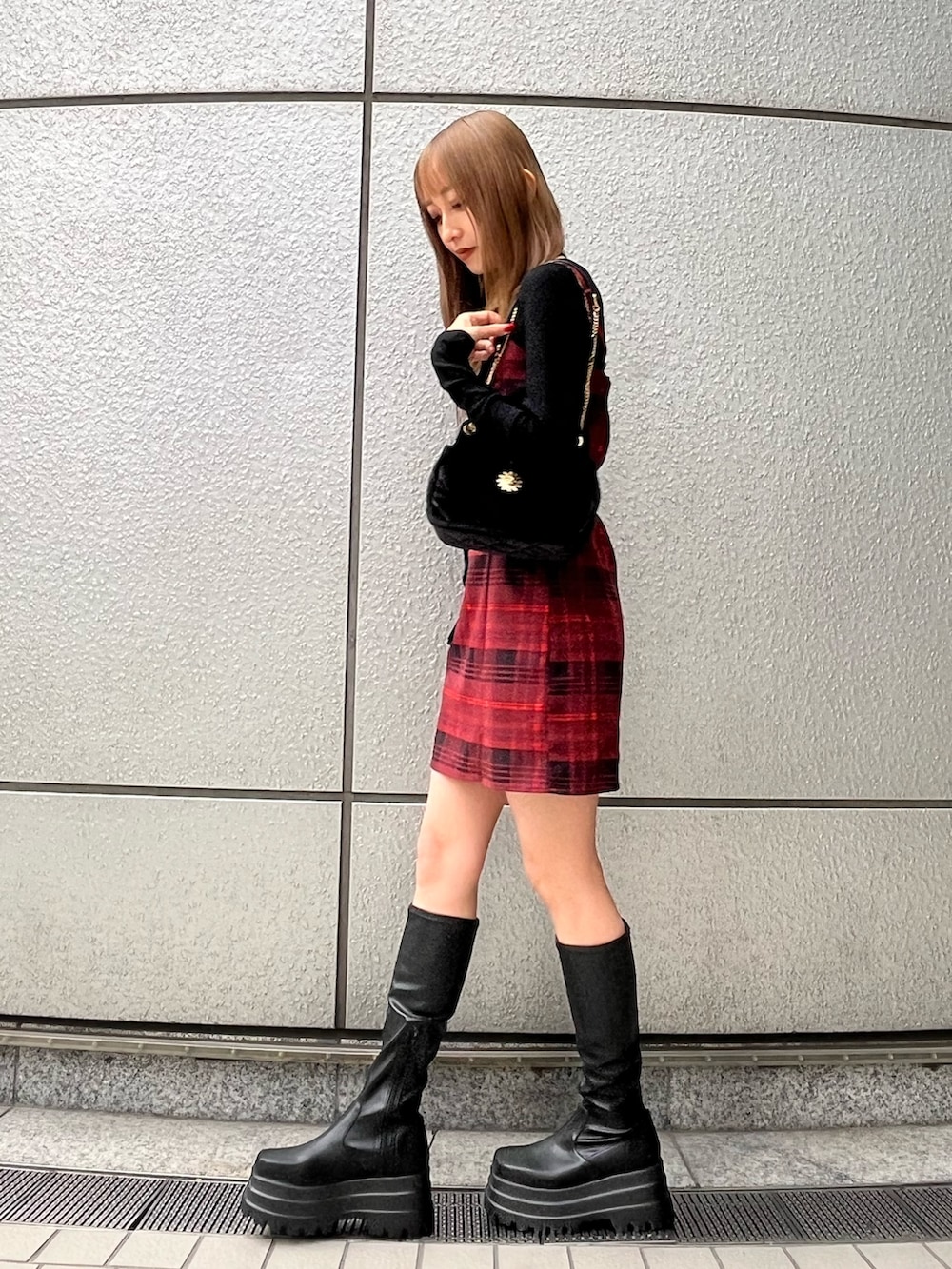ブラック系のTシャツ/カットソー、レッド系のワンピース、ブラック系のブーツを着用したレディースの秋コーディネートの2枚目の写真