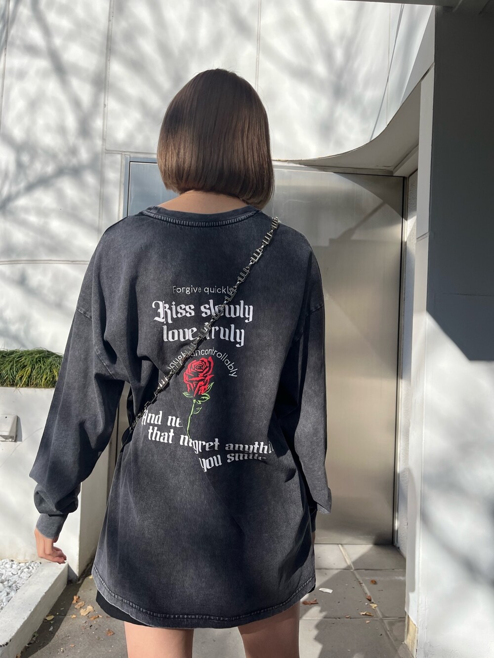 グレー系のTシャツ/カットソー、ブラック系のショルダーバッグ、ブラック系のブーツを着用したレディースの冬コーディネートの5枚目の写真