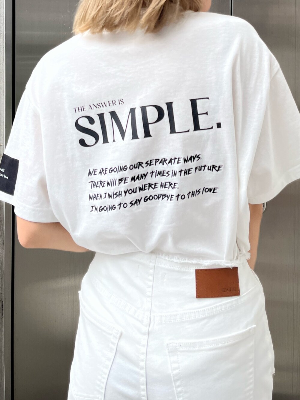 ホワイト系のデニムパンツ、ホワイト系のTシャツ/カットソー、ブラック系のスニーカーを着用したレディースの春コーディネートの6枚目の写真