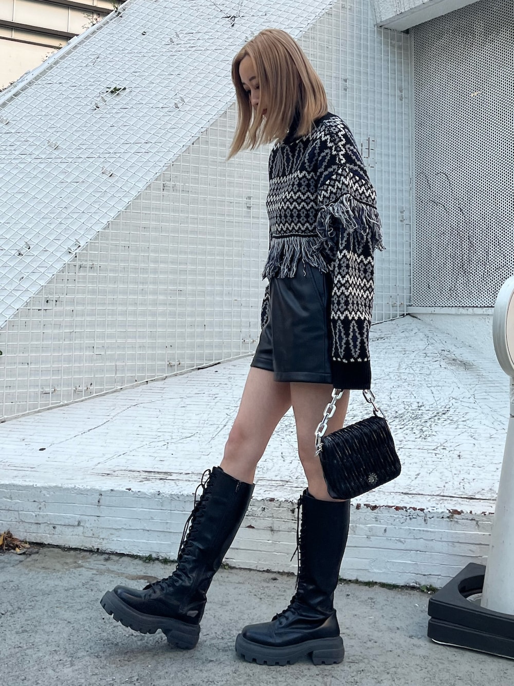 ブラック系のニット/セーター、ベージュ系のその他パンツ、ブラック系のブーツを着用したレディースの冬コーディネートの2枚目の写真