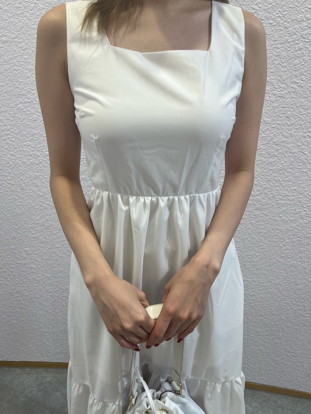 ホワイト系のサンダル、ホワイト系のショルダーバッグ、ホワイト系のワンピースを着用したレディースの夏コーディネートの5枚目の写真