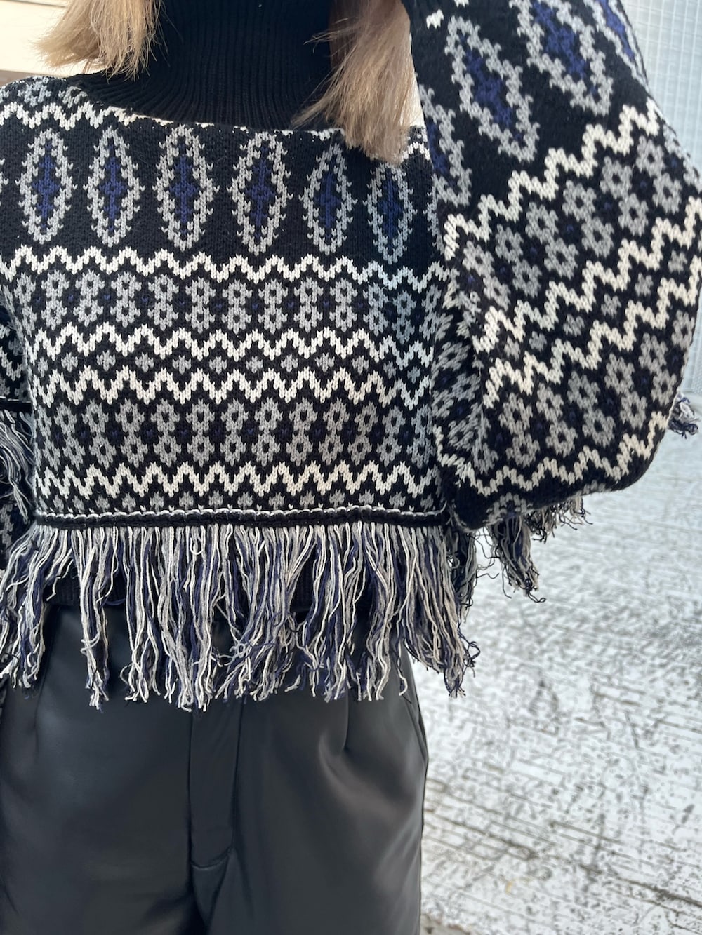 ブラック系のニット/セーター、ベージュ系のその他パンツ、ブラック系のブーツを着用したレディースの冬コーディネートの6枚目の写真