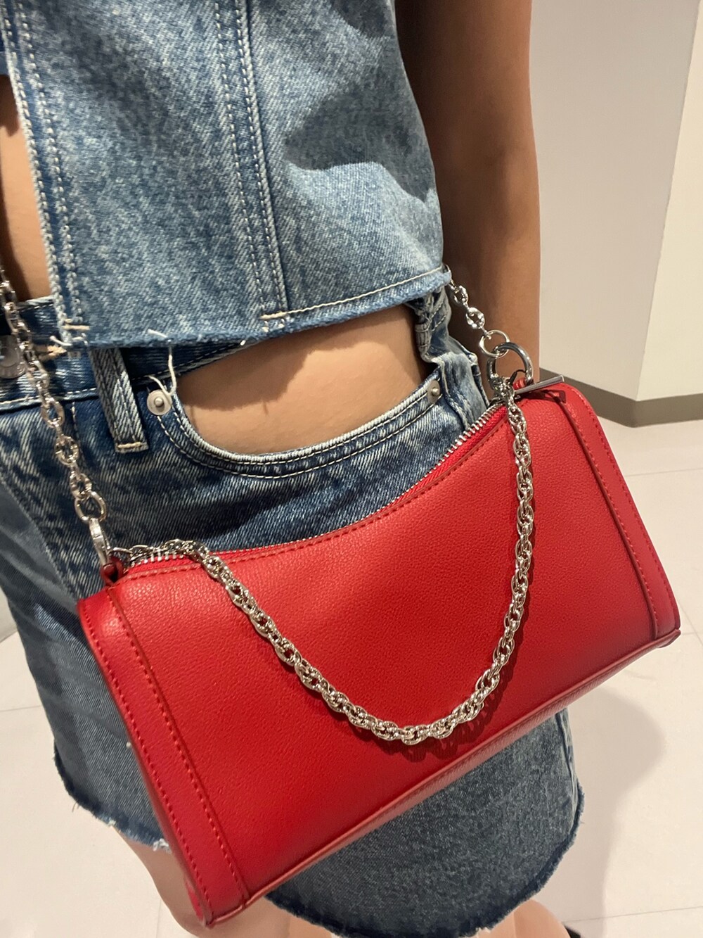 ブルー系のキャミソール、ブラック系のデニムスカート、シルバー系のブーツを着用したレディースの夏コーディネートの3枚目の写真