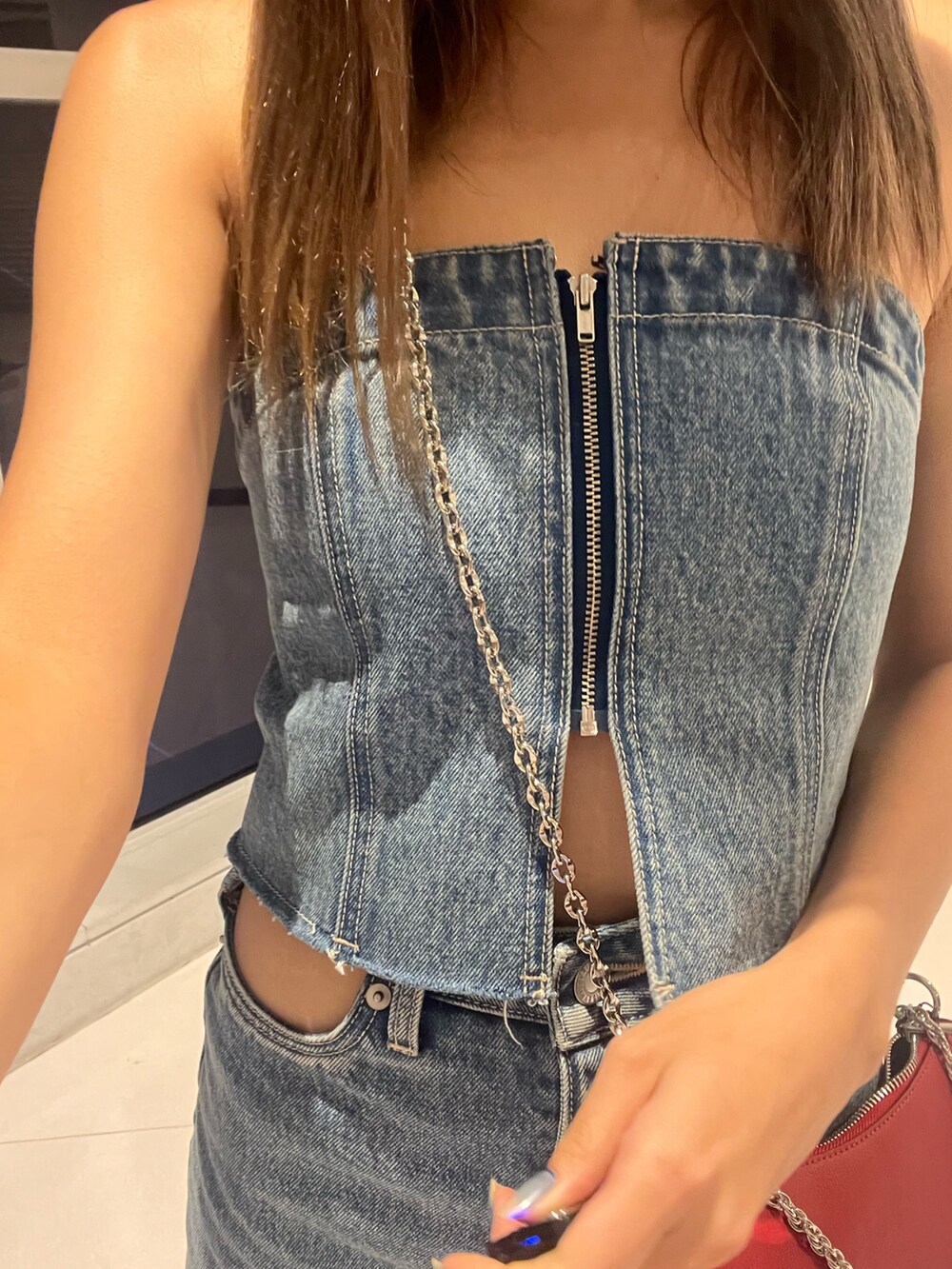 ブルー系のキャミソール、ブラック系のデニムスカート、シルバー系のブーツを着用したレディースの夏コーディネートの4枚目の写真