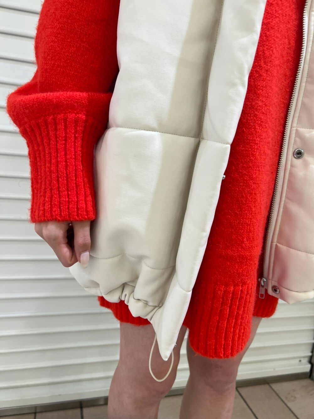 ホワイト系のブルゾン、レッド系のワンピースを着用したレディースの秋コーディネートの5枚目の写真