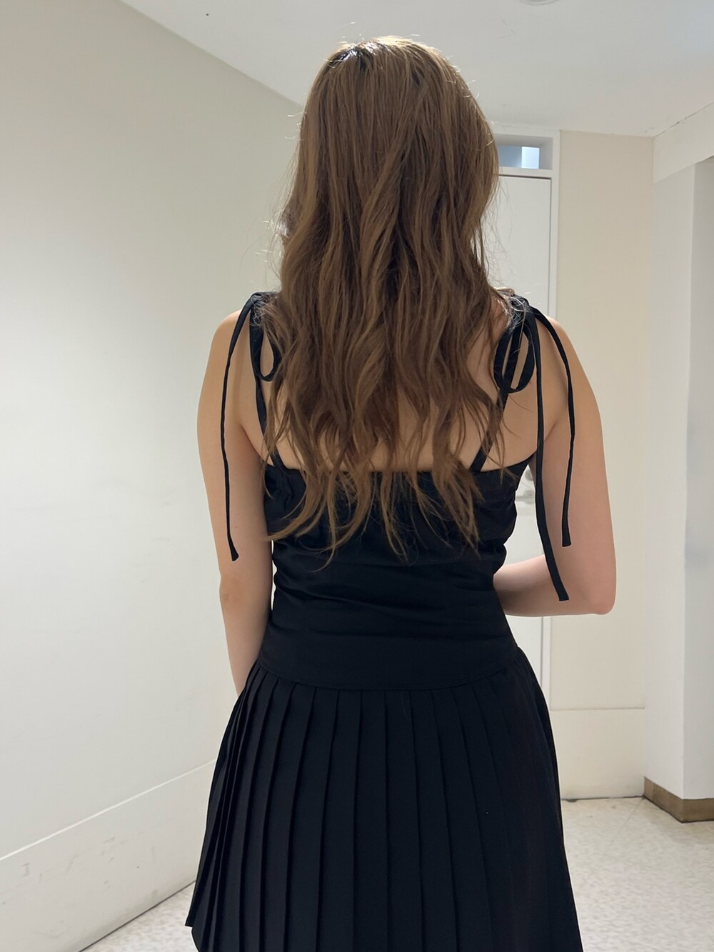 ブラウン系のハンドバッグ、ブラック系のブーツ、ブラック系のワンピースを着用したレディースの夏コーディネートの5枚目の写真