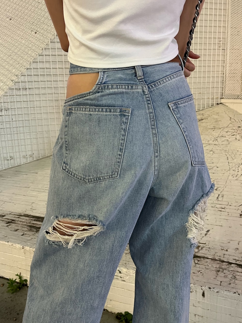 ブルー系のデニムパンツ、ホワイト系のTシャツ/カットソー、ブラック系のショルダーバッグを着用したレディースの夏コーディネートの7枚目の写真