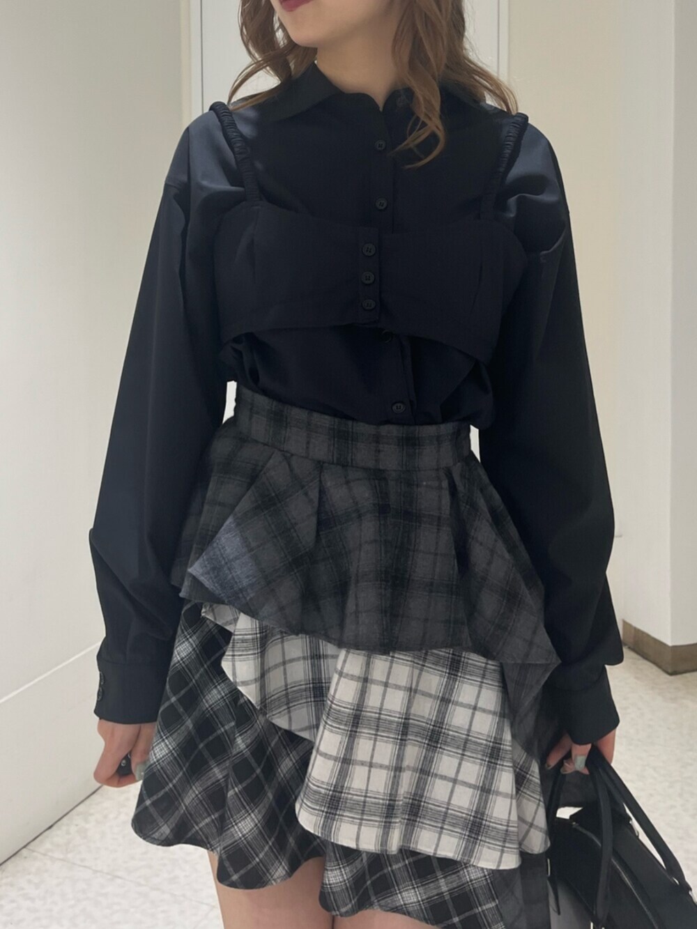 ブラック系のブーツ、ブラック系のボストンバッグ、ブラック系のスカートを着用したレディースの春コーディネートの5枚目の写真