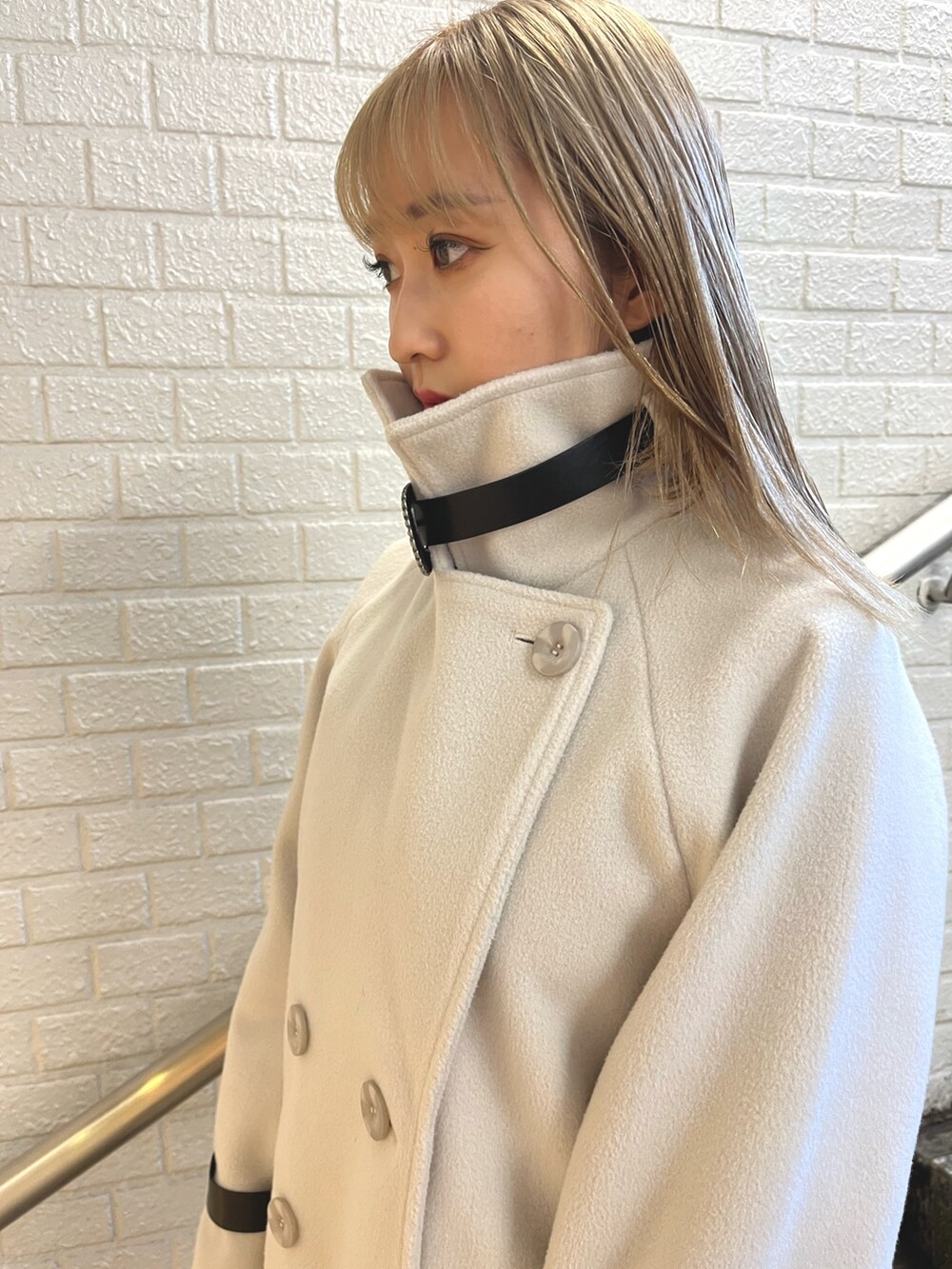 ホワイト系のその他アウター、ブラック系のその他パンツ、ブラック系のショルダーバッグを着用したレディースの冬コーディネートの4枚目の写真