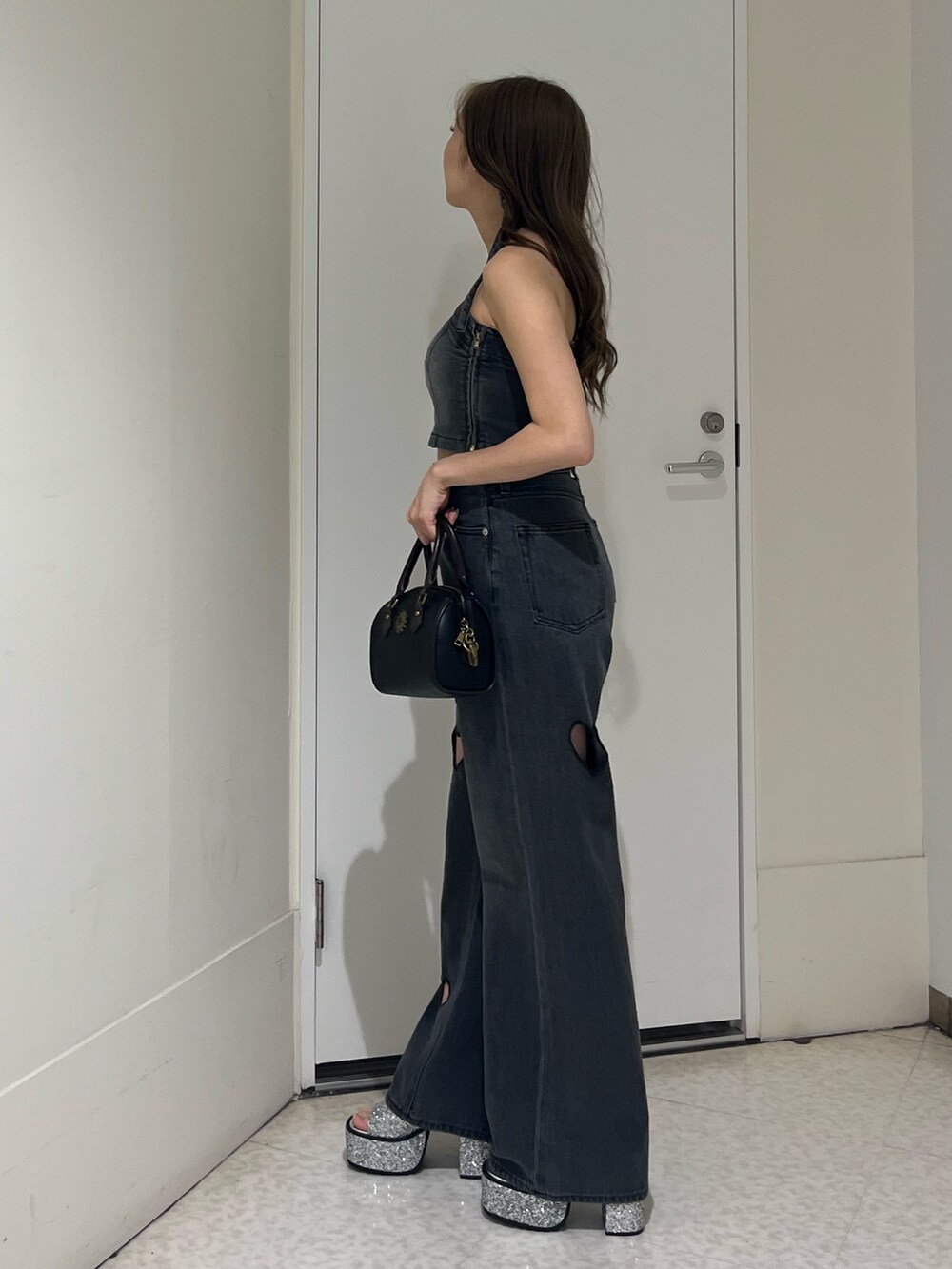 ブラック系のキャミソール、ブラック系のデニムパンツ、シルバー系のサンダルを着用したレディースの夏コーディネートの2枚目の写真