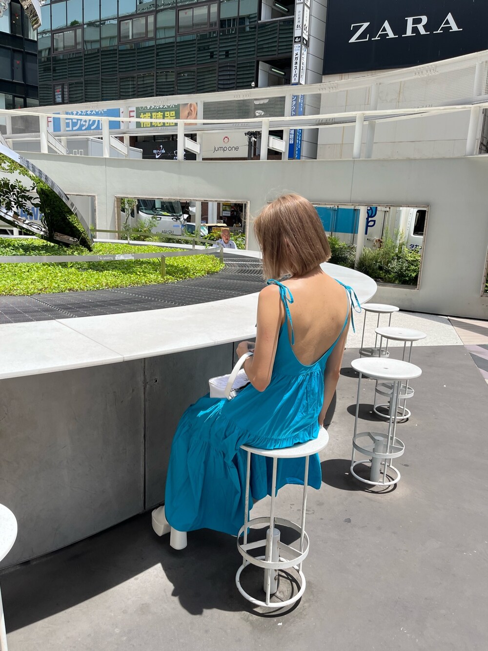 ホワイト系のサンダル、ブラック系のワンピースを着用したレディースの夏コーディネートの5枚目の写真