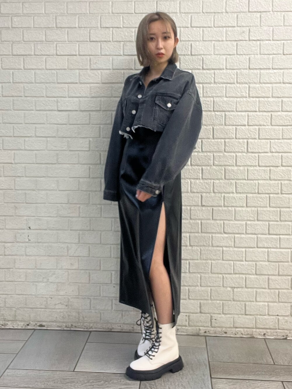 ブラック系のワンピース、ブルー系のデニムジャケット、ホワイト系のブーツを着用したレディースの冬コーディネートの2枚目の写真