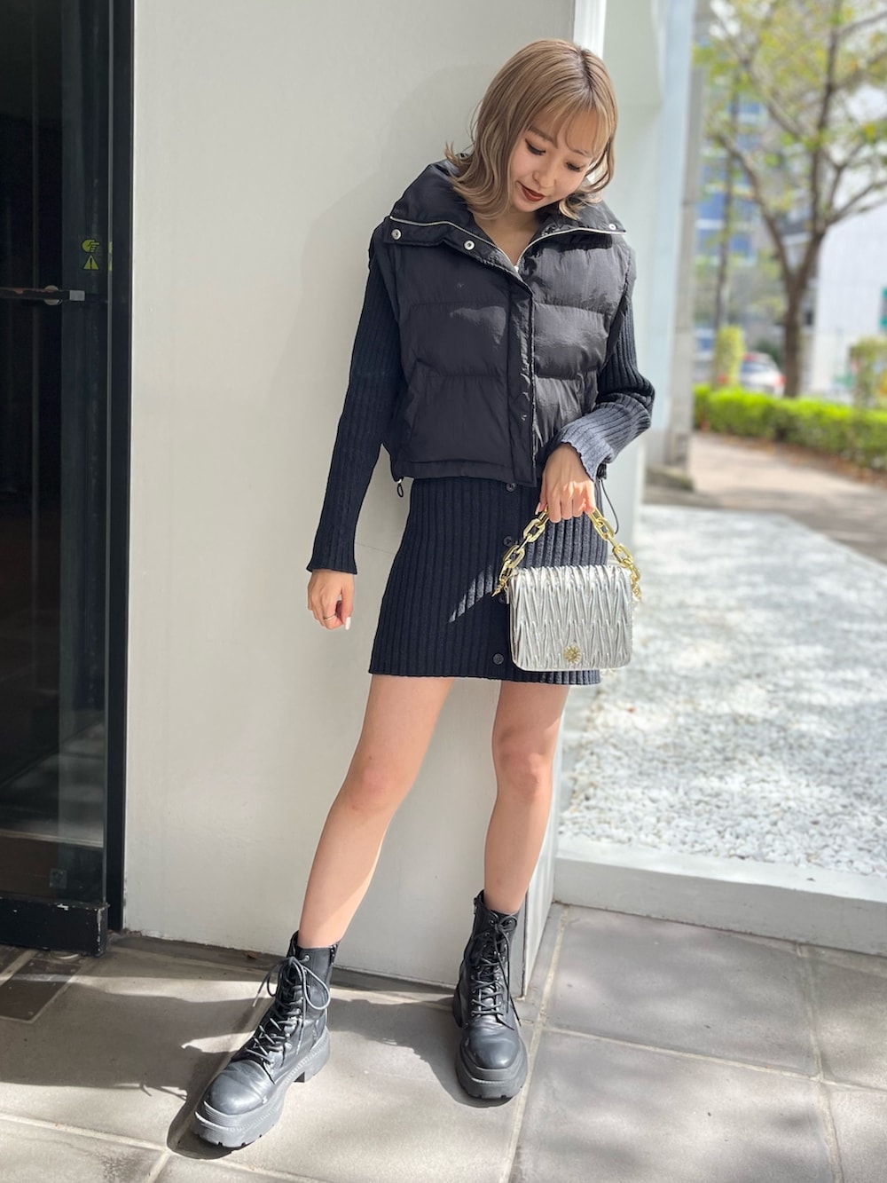 ホワイト系のブーツ、シルバー系のショルダーバッグ、ブラック系のワンピースを着用したレディースの秋コーディネートの2枚目の写真