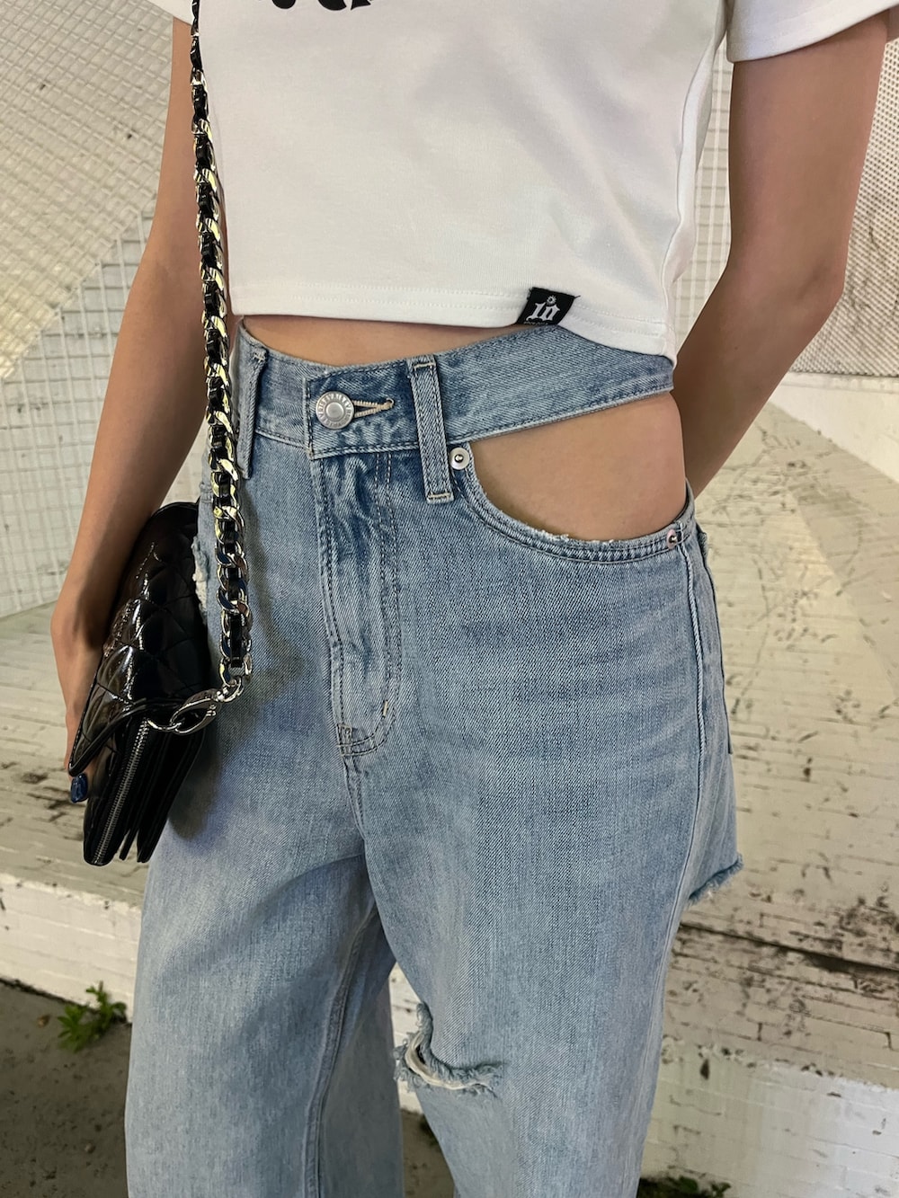 ブルー系のデニムパンツ、ホワイト系のTシャツ/カットソー、ブラック系のショルダーバッグを着用したレディースの夏コーディネートの5枚目の写真