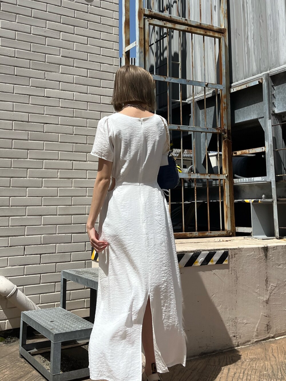 ホワイト系のワンピース、ベージュ系のサンダル、ブルー系のショルダーバッグを着用したレディースの春コーディネートの10枚目の写真